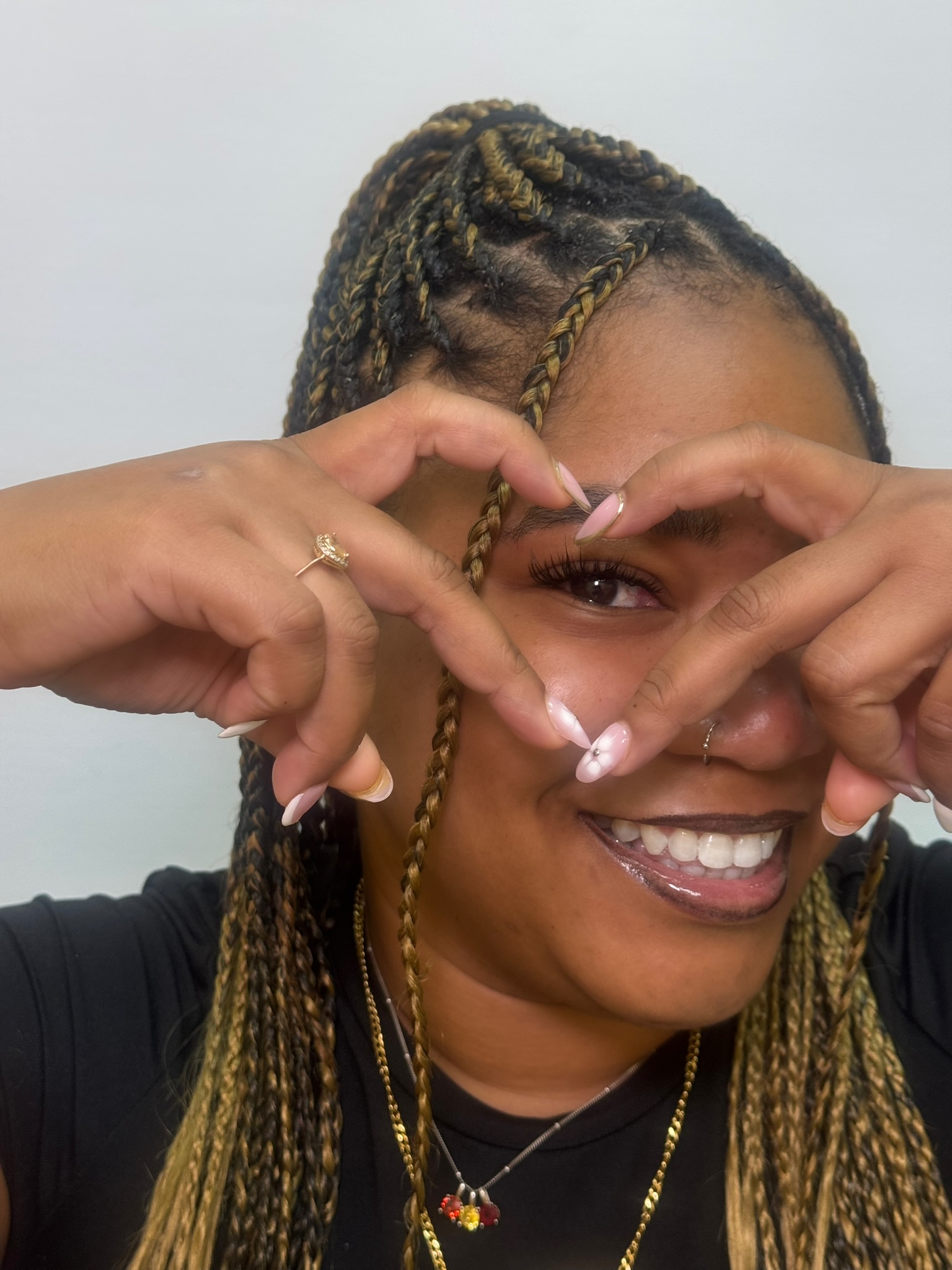 Happy client making heart with hands showing lash results