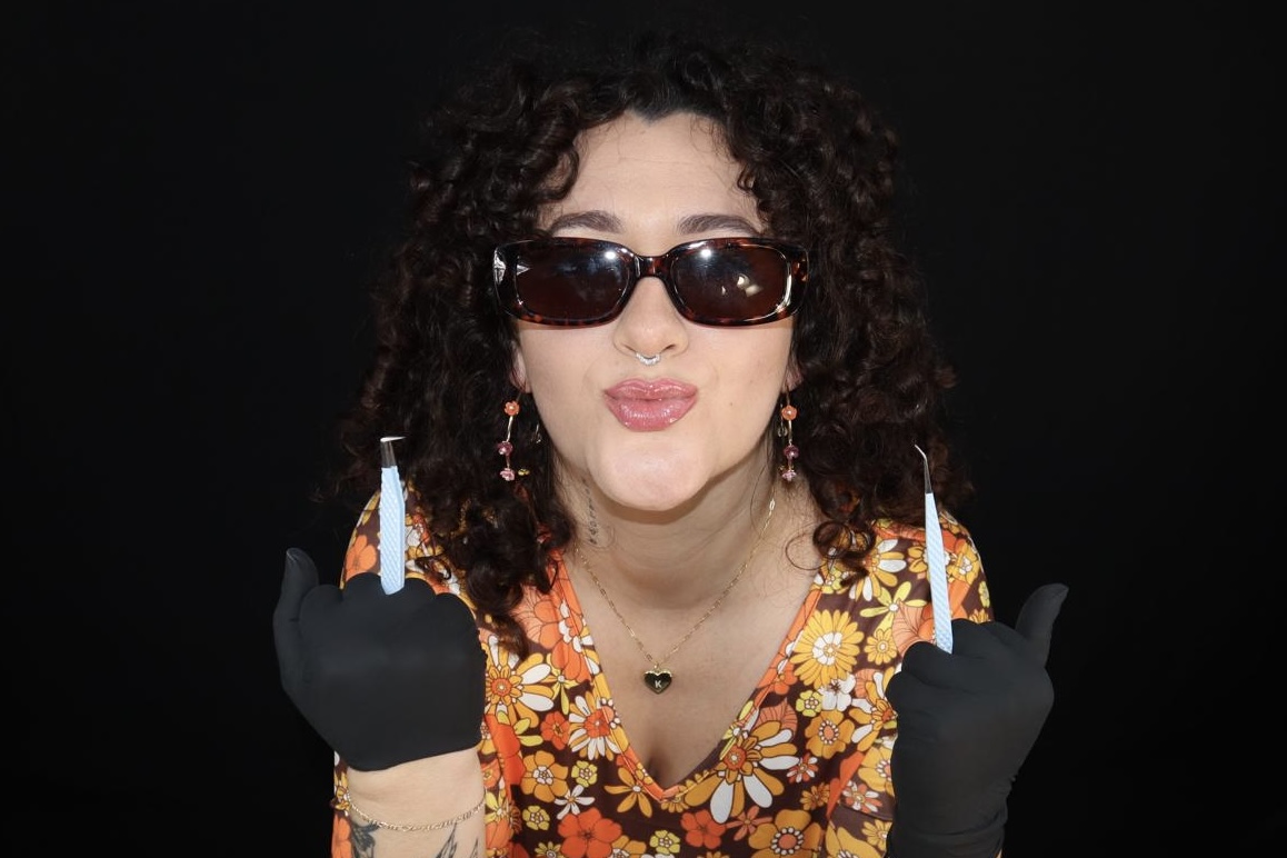 Jackiee with sunglasses holding lash tweezers